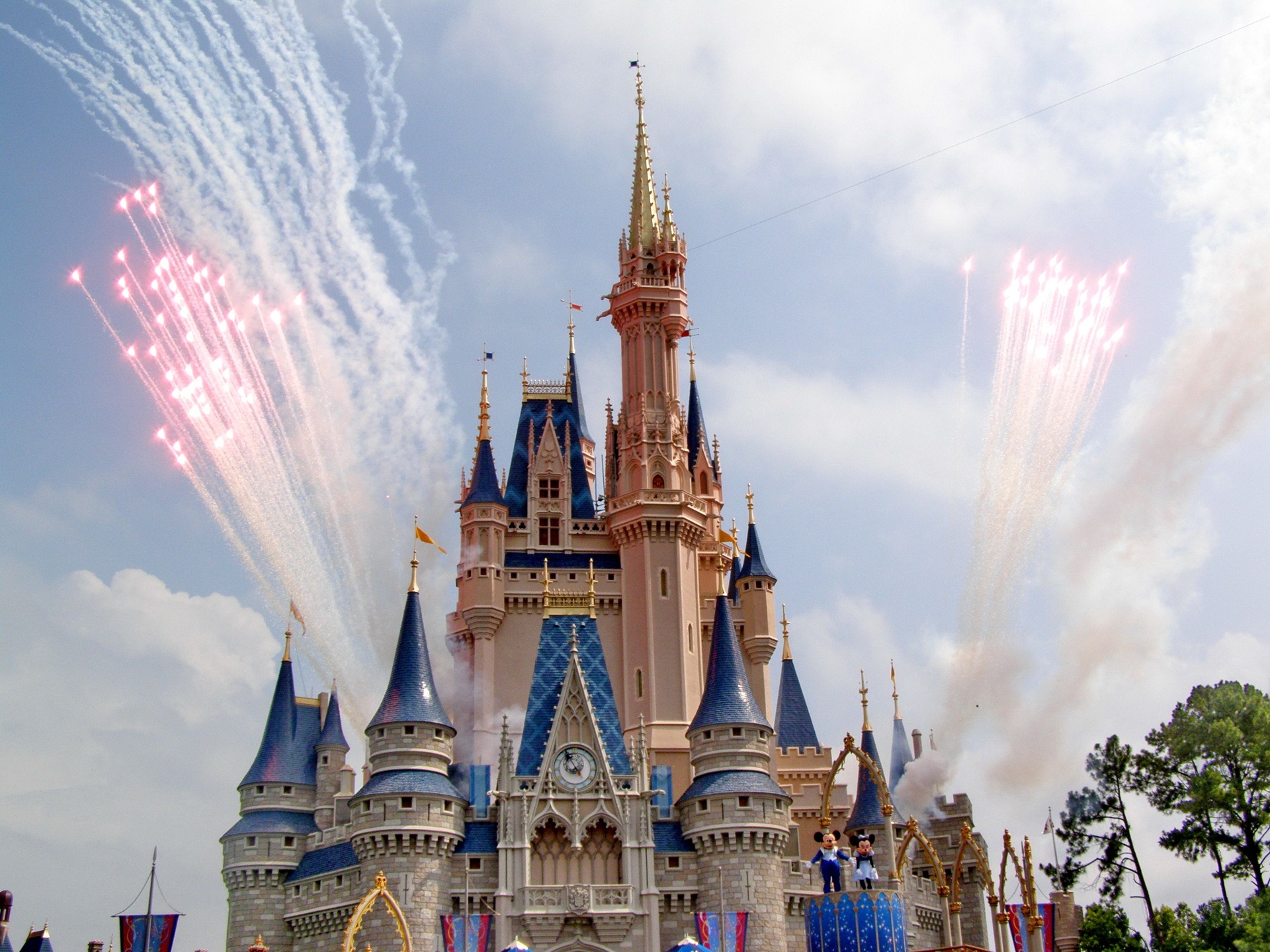 Cinderella Castle with pink fireworks bursting across a blue sky