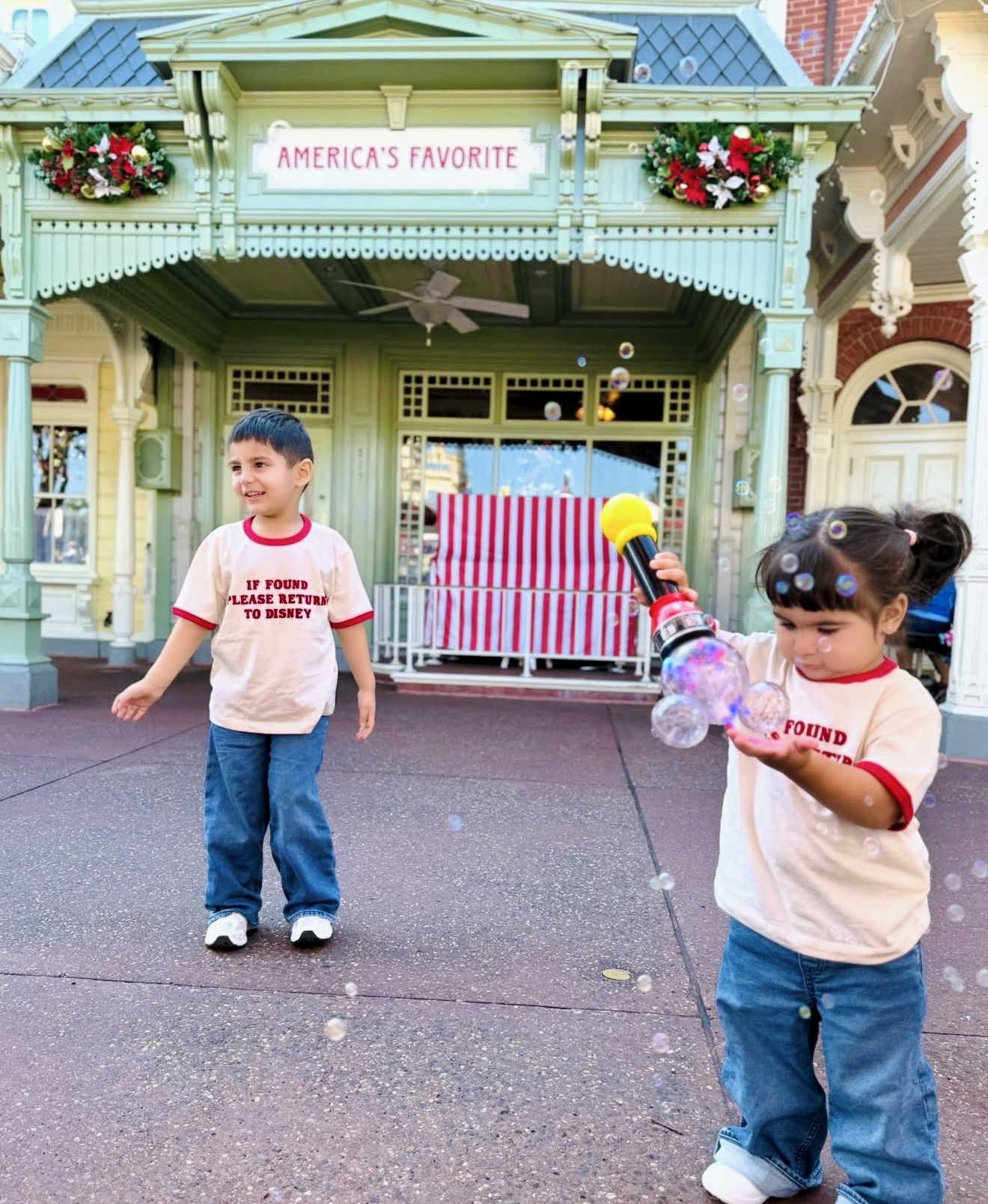 Two young clients playing with bubbles on Main Street U.S.A.